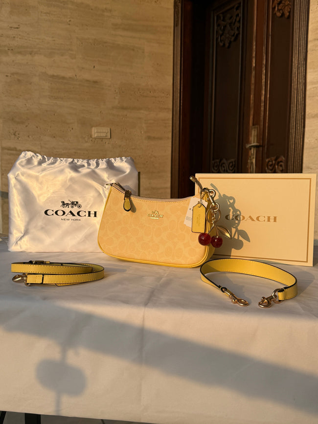 COACH LIGHT PASTEL YELLOW BAG WITH CHERRY CHARM AND 2 STRIPS Hover Image