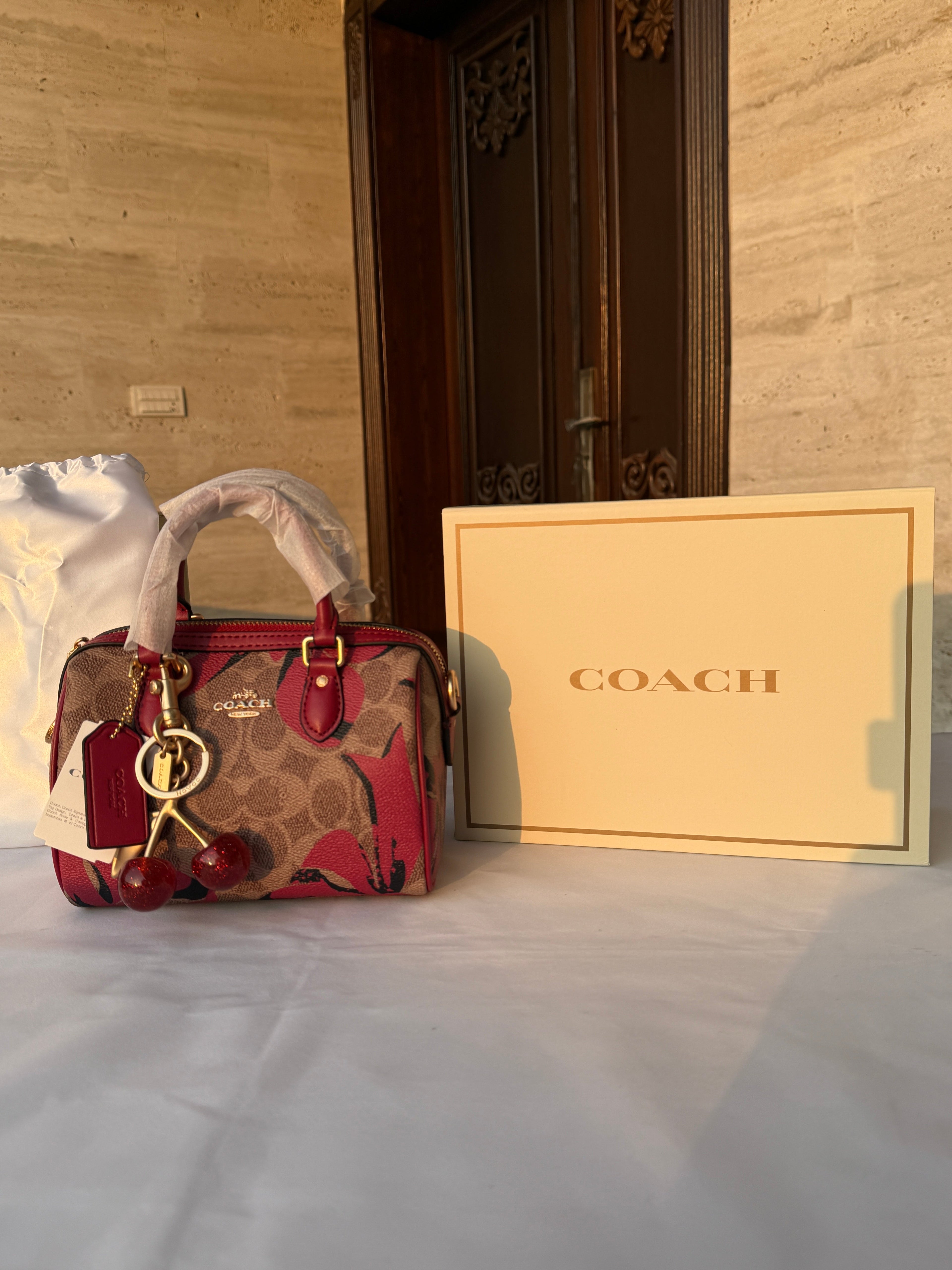 COACH BROWN AND RED PATTERN BAG WITH CHERRY CHARM