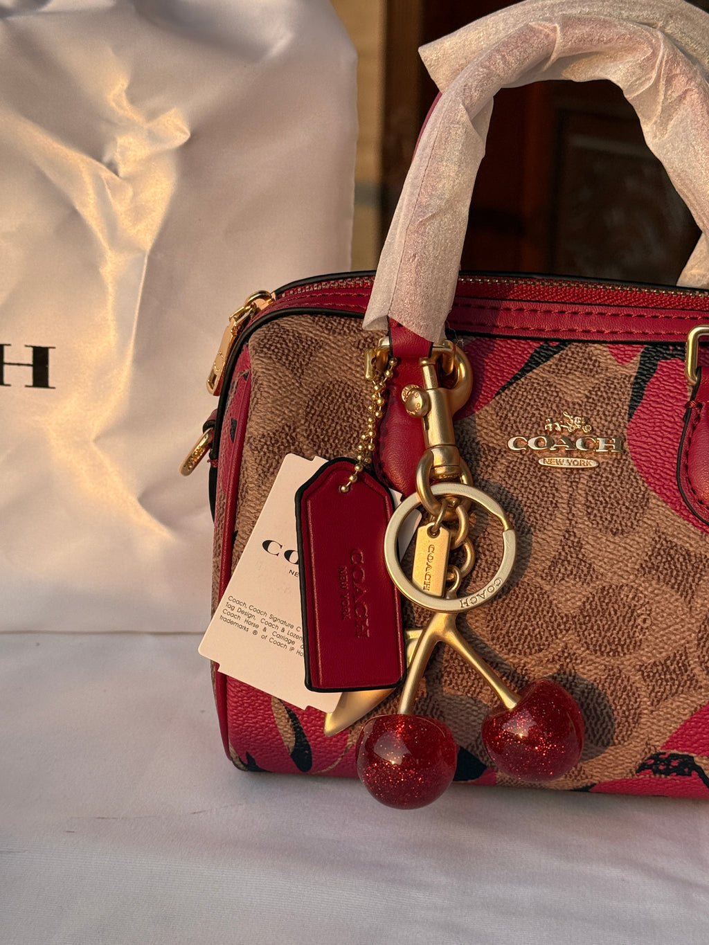 COACH BROWN AND RED PATTERN BAG WITH CHERRY CHARM