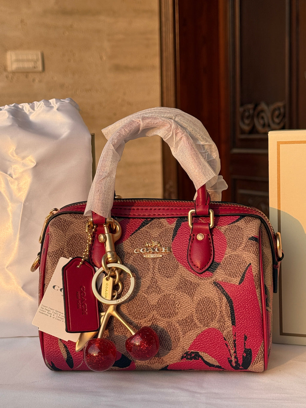 COACH BROWN AND RED PATTERN BAG WITH CHERRY CHARM