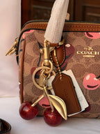COACH LIGHT BROWN /TAN BASE CHERRY PATTERN BAG WITH CHERRY CHARM